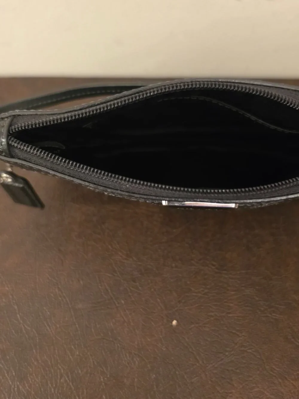 The Coach Signature Stitched Patent Leather Wristlet in black silver